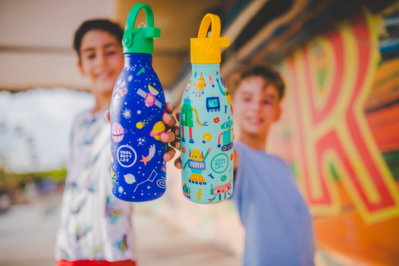 Niños sosteniendo dos botellas reutilizables de acero inoxidable